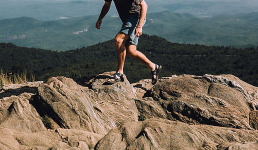 man walking on rock at daytime thumbnail