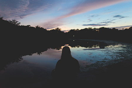 silhouette of person facing body of water thumbnail