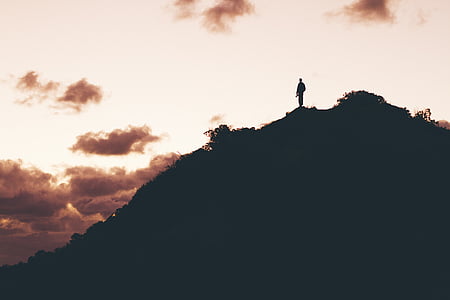 silhouette photo of man on top of hill thumbnail