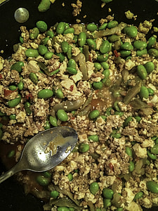 Beans, tofu, and pork being stir fried thumbnail