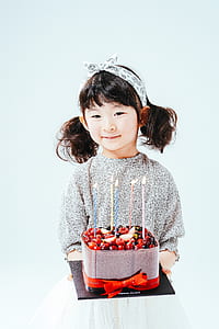 girl holding strawberry cake with lighted candles thumbnail