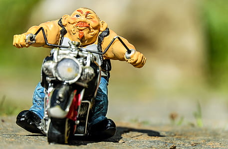 man riding on motorcycle die-cast model on sand thumbnail