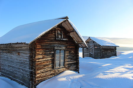 two brown cabins surrounded by snow-covered land thumbnail