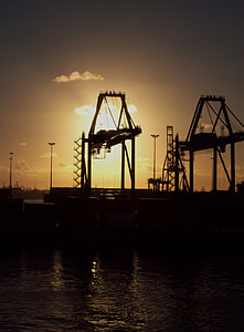 silhouette of equipment near body of water at sunset thumbnail