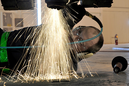 photography of man wearing earmuffs welding thumbnail