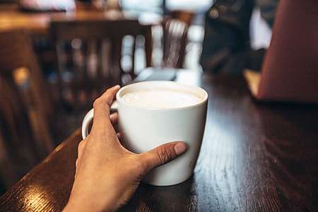 Cafe coffee cup being held in a hand thumbnail