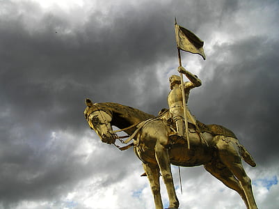 man riding on horse statue under gray clouds thumbnail
