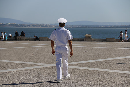 man in white suit and hat standing on gray pavement during daytime thumbnail