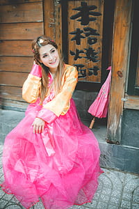 smiling woman sitting near pink umbrella thumbnail