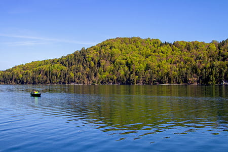 sail boat on water near mountain thumbnail