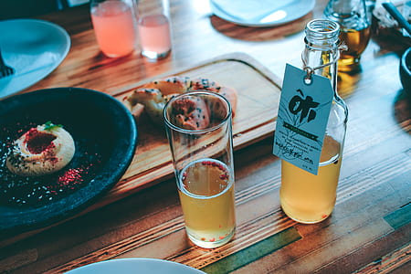 Clear Glass Bottle and Drinking Glass With Brown Liquid thumbnail