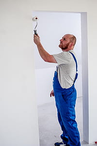 man standing while painting the doorway using white paint roll thumbnail