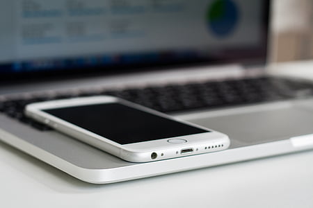 turned-off silver iPhone 6 on top of MacBook Pro thumbnail