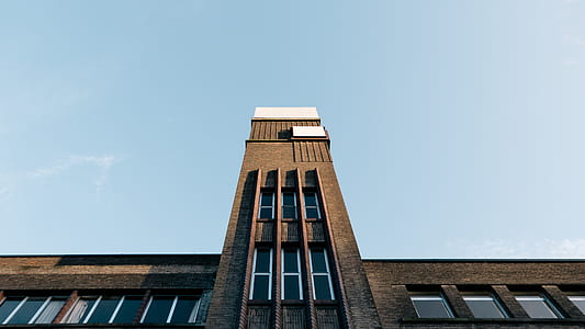 brown concrete building under clear blue sky thumbnail