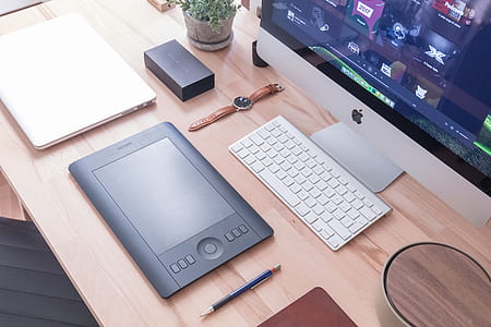 silver iMac on brown wooden desk thumbnail