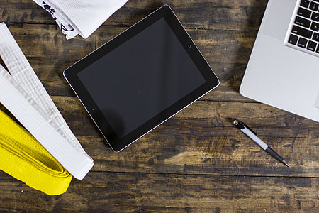 black iPad beside silver MacBook and retractable pen thumbnail