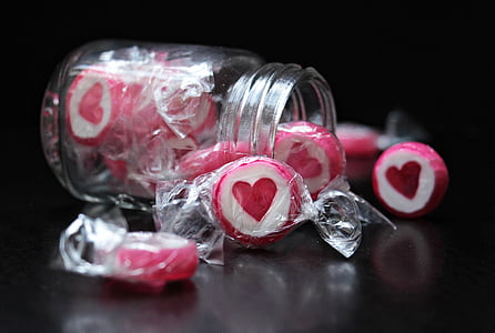 person taking photo of white-and-pink candies with jar thumbnail