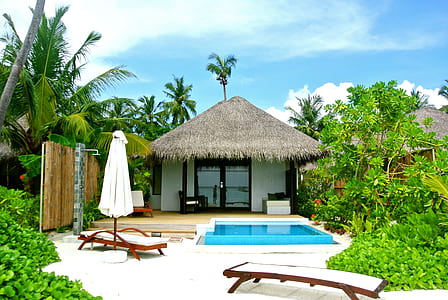 landscape photo of two house behind swimming pool with two loungers thumbnail