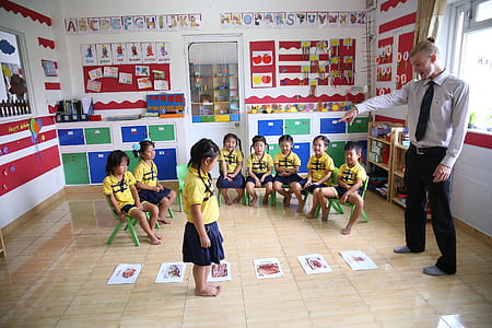 man pointing girl standing in center of room thumbnail