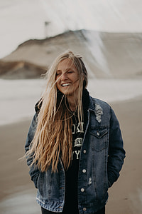 woman in blue denim jacket smiling while her hands in pocket thumbnail