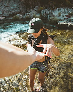 person taking hand of woman while crossing on body of water thumbnail