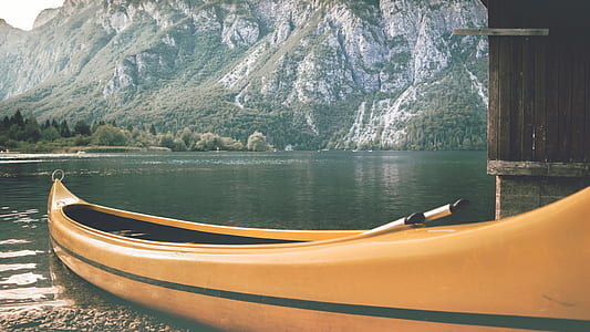 orange paddle boat docked on gray soil thumbnail