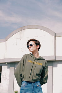 woman standing in front of white building during daytime thumbnail