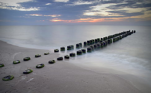 black stepping stones on seashore during daytime thumbnail