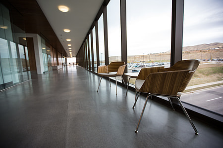two brown wooden chairs with table on hallway thumbnail
