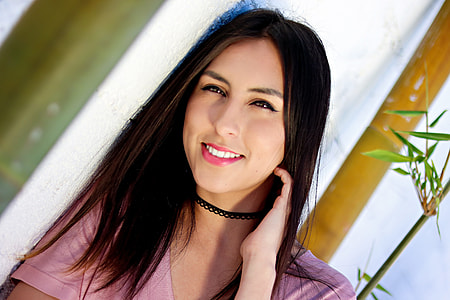 woman wearing pink t-shirt lining on white wall thumbnail