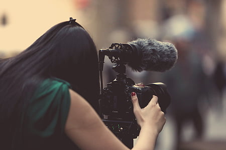 woman using black DSLR camera thumbnail