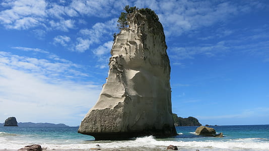 gray monolith on body of water under white sky thumbnail
