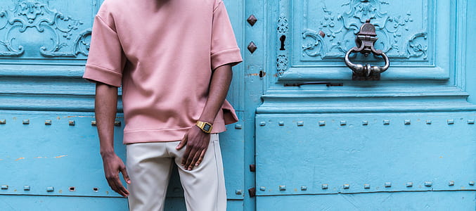 man standing beside teal wooden door thumbnail