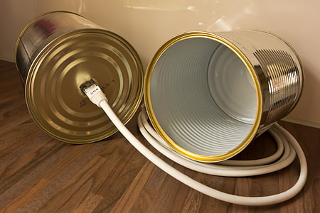 gray tin can telephone toy on brown wooden parquet floor thumbnail