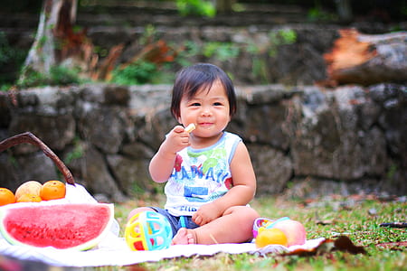 girl sitting on mat near fruit of basket thumbnail
