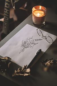 flower sketch beside eyeglasses and candle thumbnail