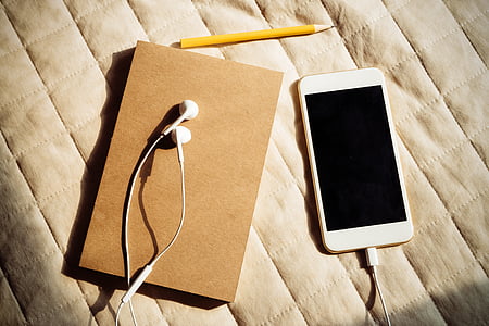 white Android smartphone beside white earphones thumbnail