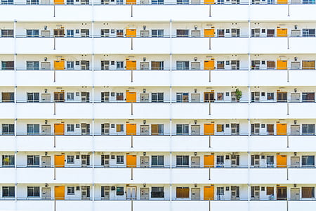 white apartment building with yellow doors thumbnail