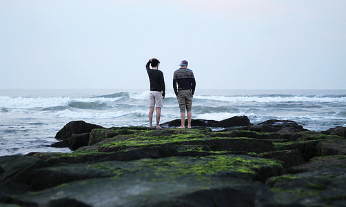 two men standing near body of water thumbnail