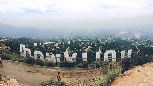 man wearing red shirt facing Hollywood signage thumbnail