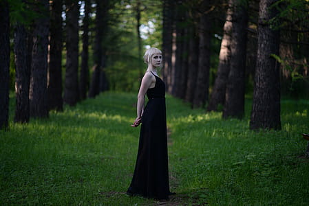 Woman Wearing Black Sleeveless Long Dress Standing Near Trees thumbnail