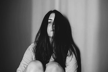 grayscale photography of woman leaning on wall thumbnail