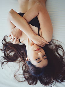woman in black brassiere on white bed thumbnail