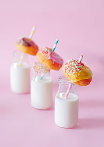 three glass bottles with milk and donuts on top thumbnail
