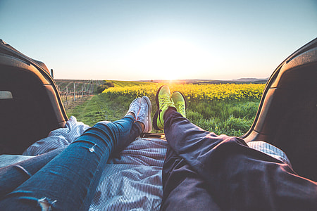 Young Couple Enjoying Romantic Sunset from Car Trunk thumbnail