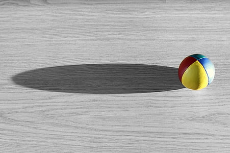 yellow, red, and blue ball on gray wooden surface thumbnail