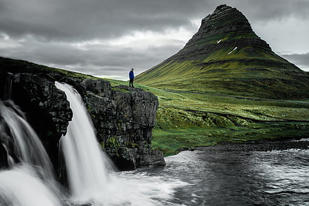 man standing near waterfalls at daytime thumbnail