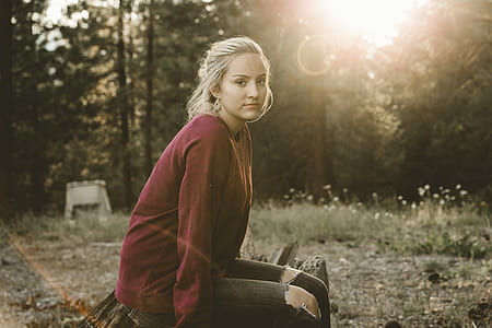 woman sitting near green leaf trees thumbnail