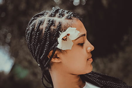 woman wearing white top with flower on her hair thumbnail
