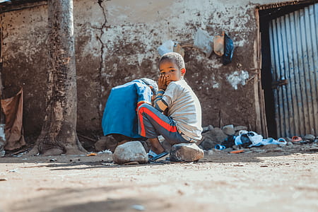 boy wearing gray shirt sitting on stone thumbnail